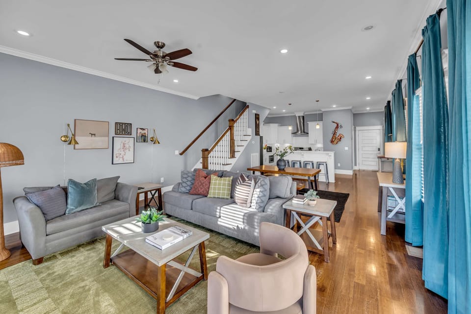 Open-plan living means the staircase, sofa, and kitchen all flow together as one gathering space. No one's left out of the conversation no matter where they land