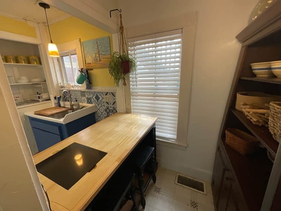 Your large food pantry has a built in, sunny breakfast nook with two stools 