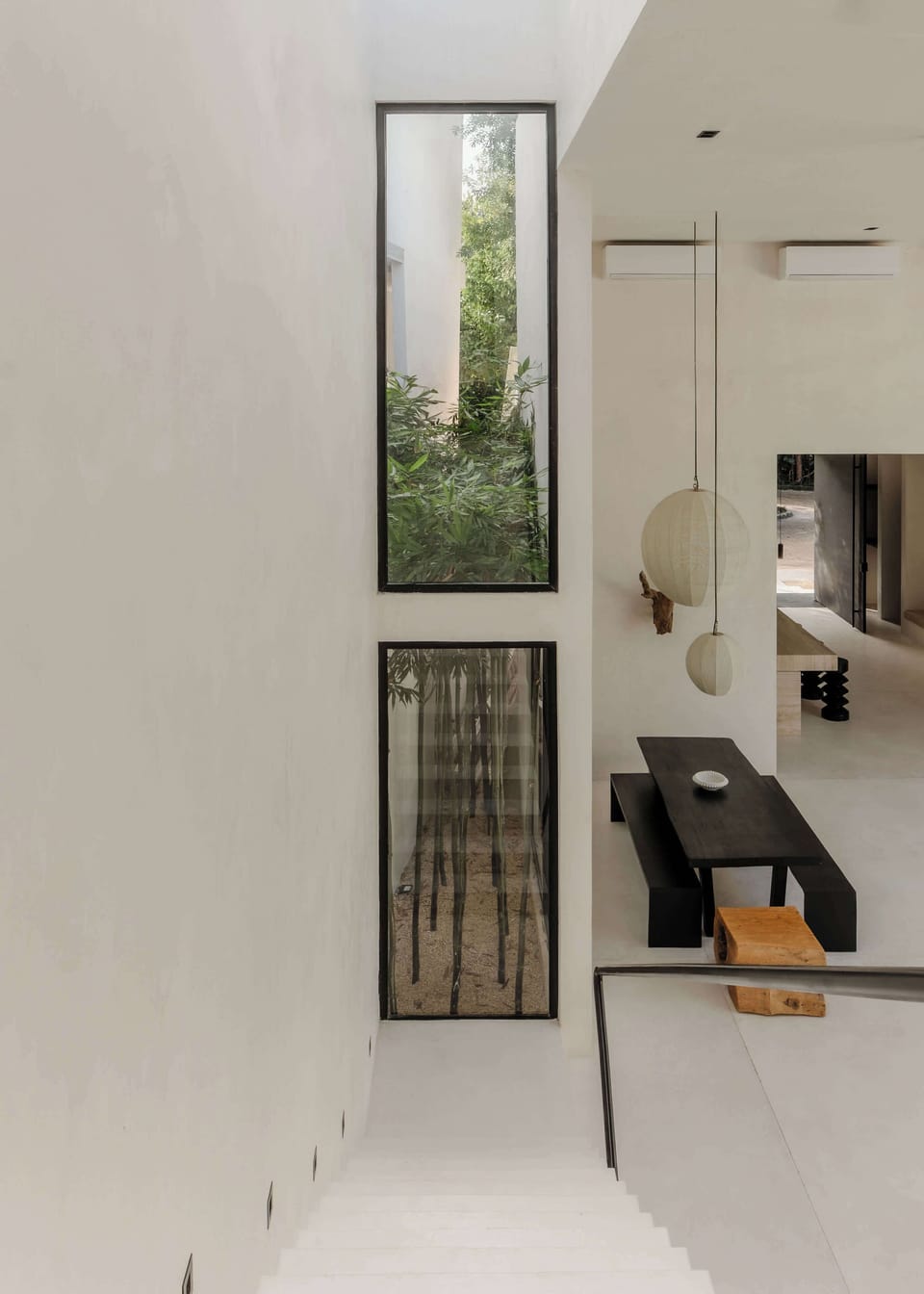 Modern staircase illuminated by full-height glass panels.
