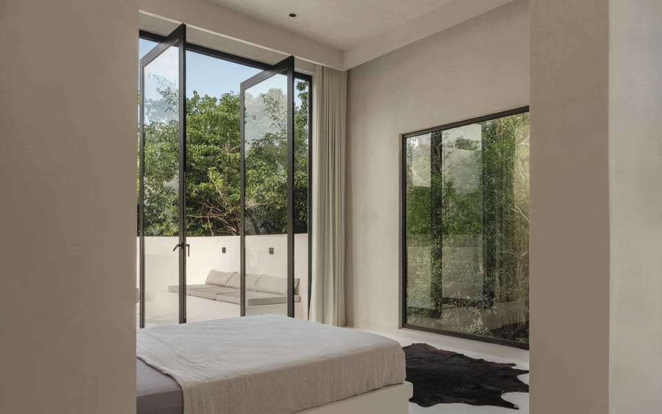 King bedroom opening to a quiet outdoor lounge area.