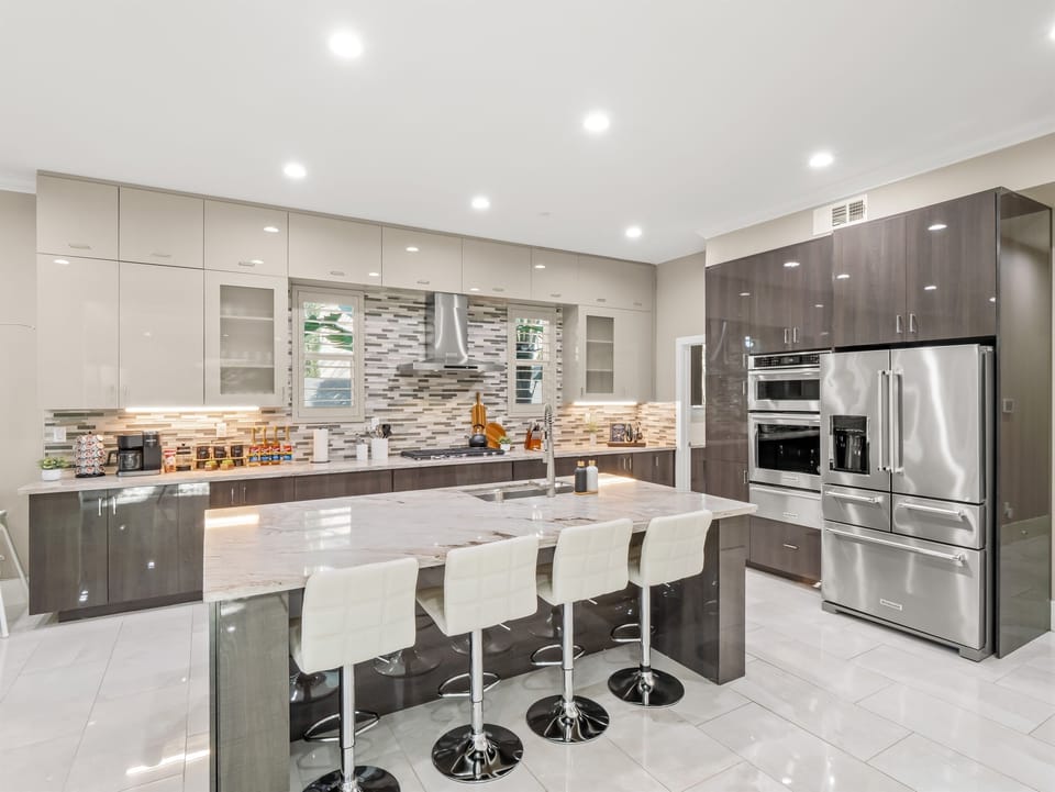 Spacious kitchen featuring a large island, bar seating, and adjacent dining area.