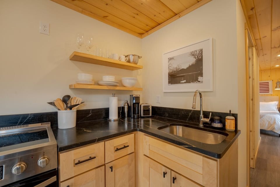 Compact yet fully stocked kitchen featuring modern appliances, natural wood cabinetry, and thoughtful design