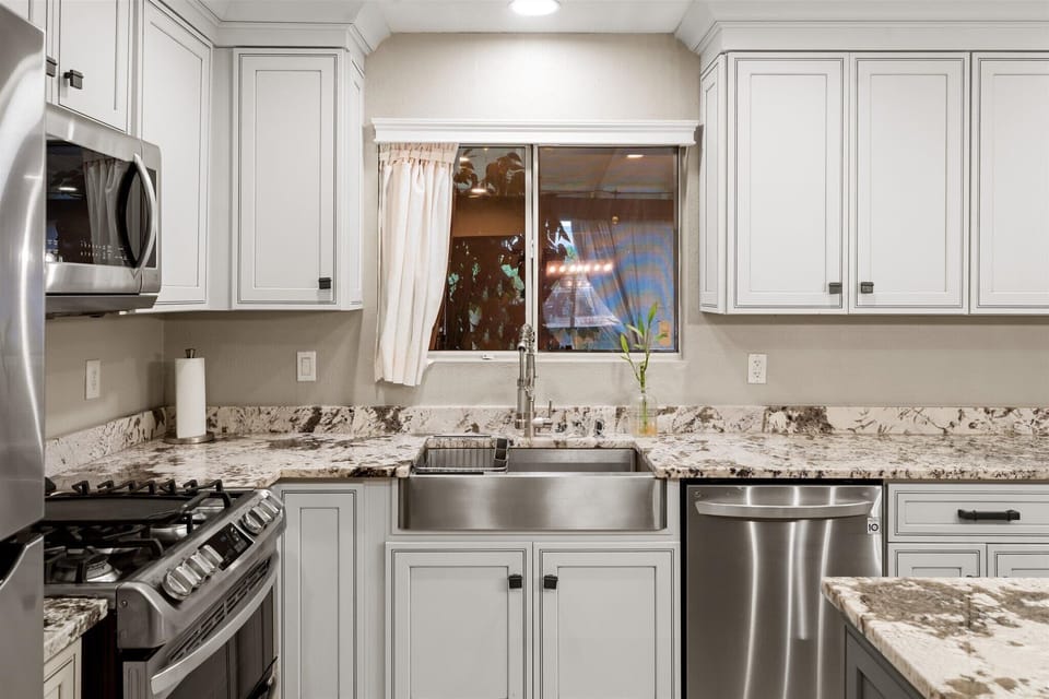 White cabinets and elegant granite countertops.
