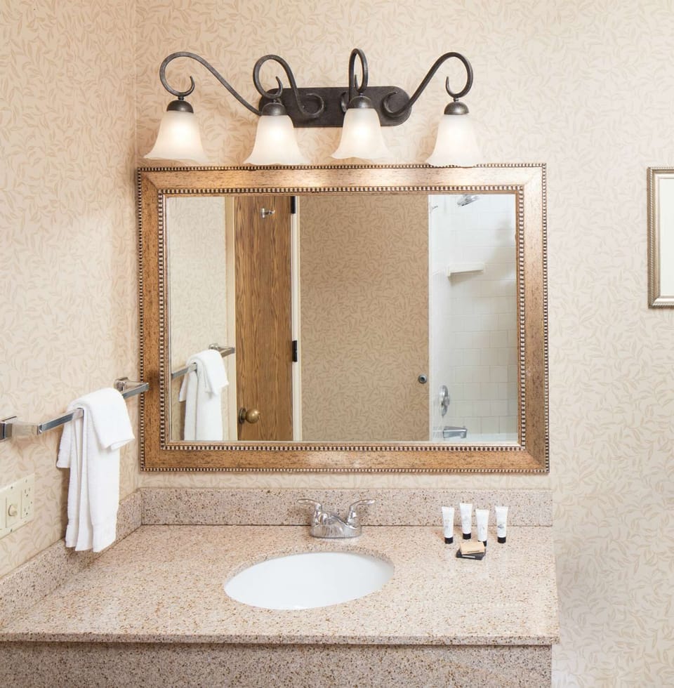 Refresh at a spotless vanity with bright lighting and plush towels.