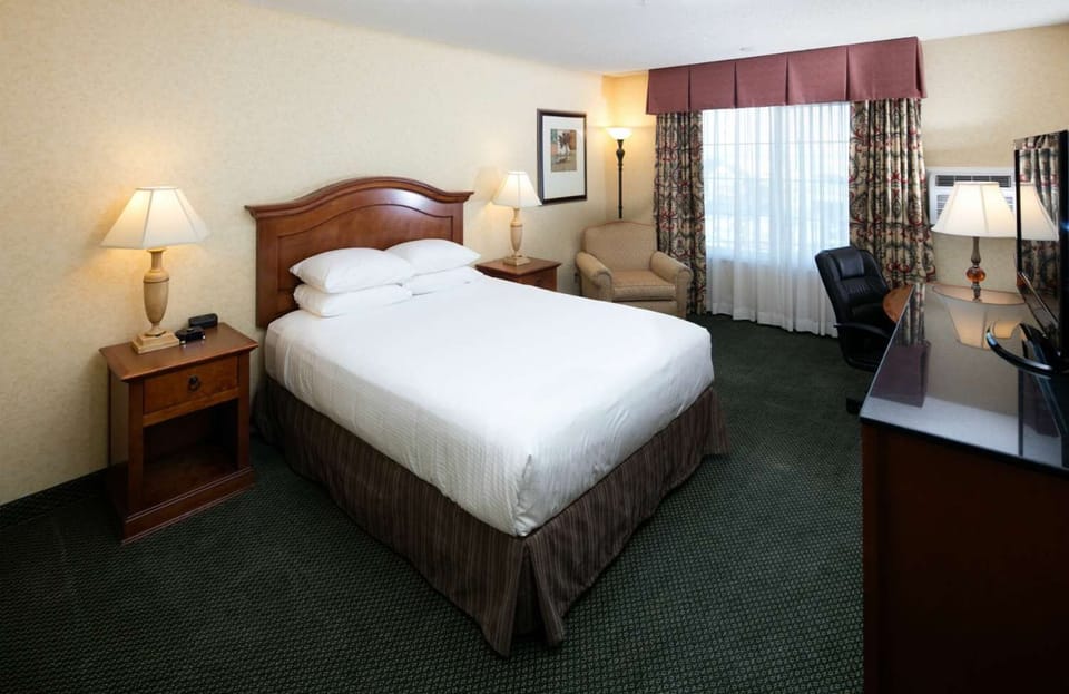 Relax after a long day in a calm, well-lit bedroom.