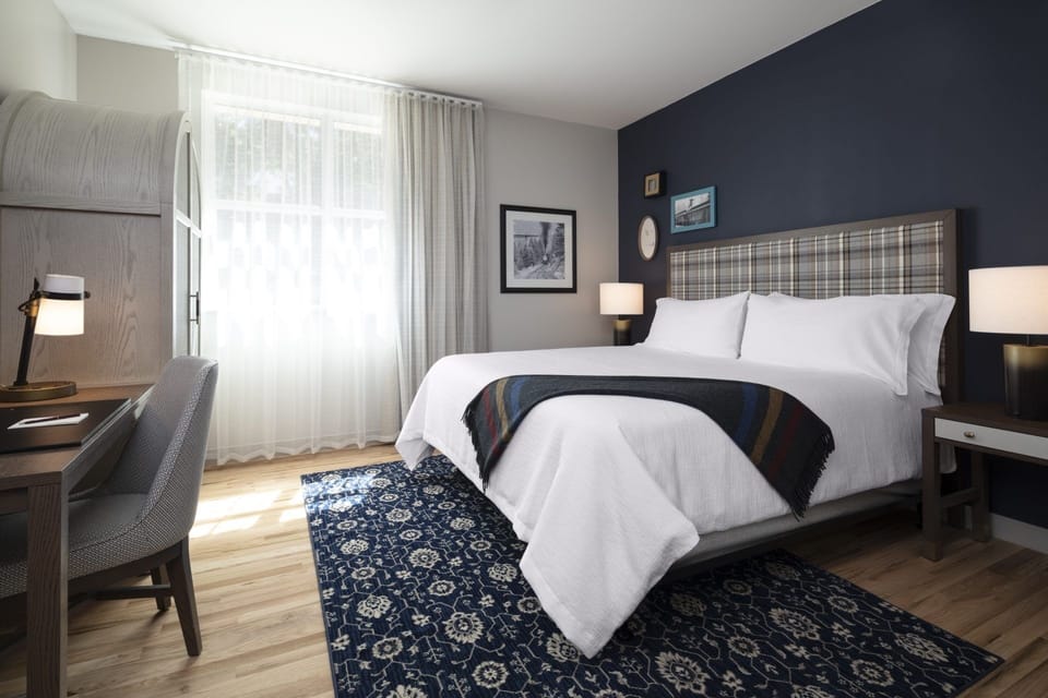 Unwind in a sunlit king bed with cozy rug.