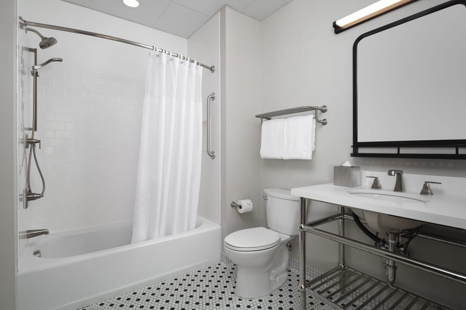Refresh in a spotless bath with bright lighting and tub.