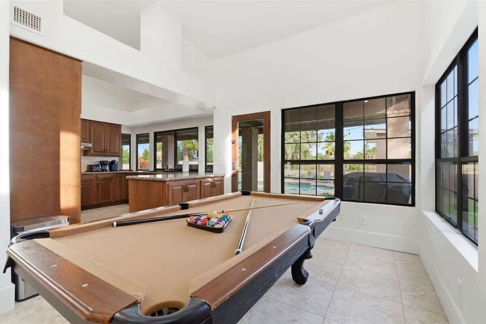 2nd living area with plush furnishings, a smart TV, fire place, and a pool table.