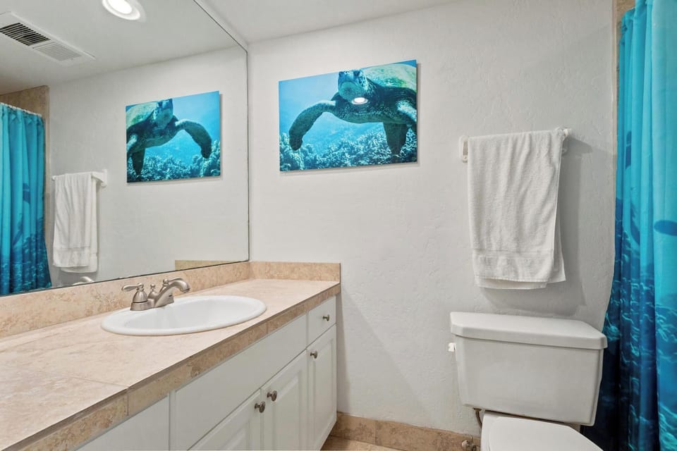 Refresh after your adventures in this bright, ocean-themed bathroom. Crisp towels and thoughtful decor create your personal sanctuary between beach days and island explorations.
