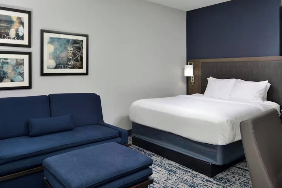 Unwind on the plush sofa beside crisp, cloud-like bedding