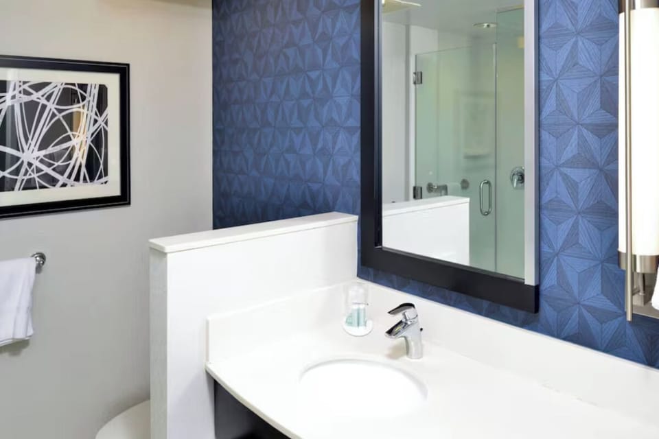 Refresh in a spotless vanity area with a bright, modern mirror.