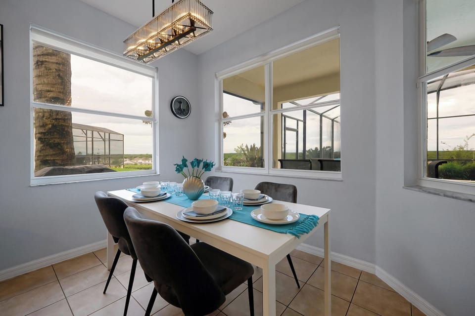 The stunning overhead chandelier, creates a warm and vibrant atmosphere to the bright delightful dinning area.