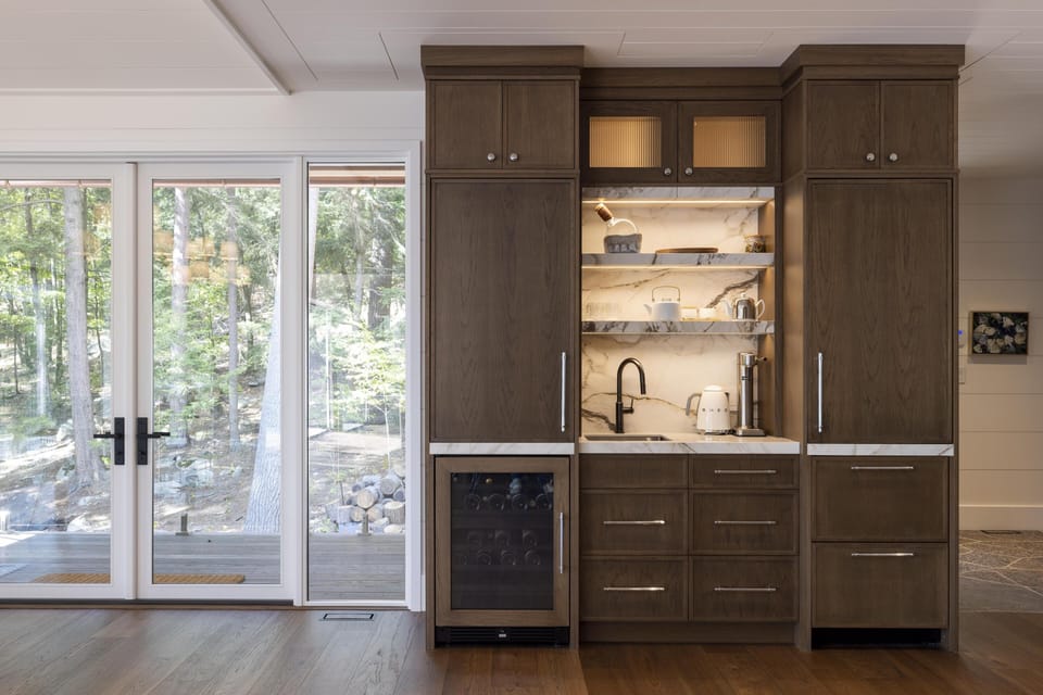 Sleek kitchenette with stone backsplash and natural light
