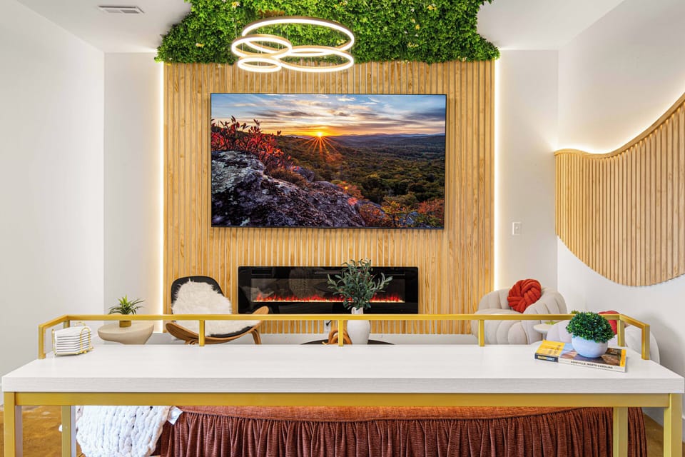 Funky ceiling lights, fresh green accents, and a giant TV create the chic lounge