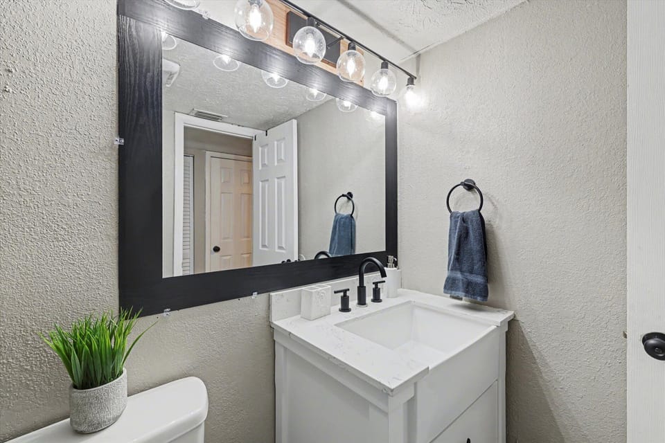 Bright updated bathroom with modern vanity and oversized mirror
