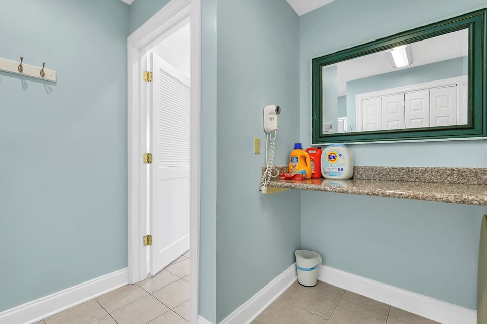 Bright laundry nook with folding counter, mirror, and guest-friendly extras