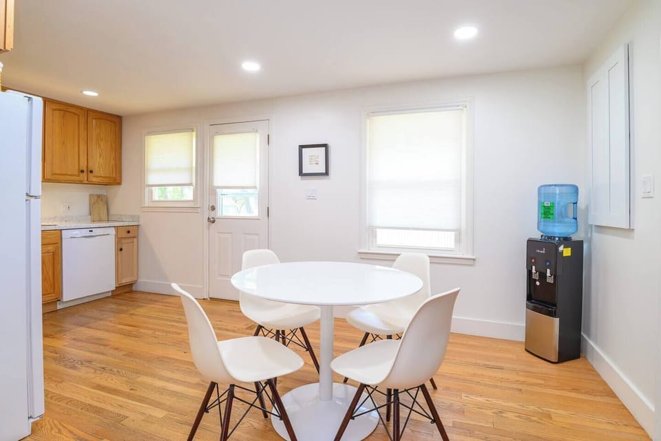 A warm, inviting dining space with seating for four, a convenient water cooler, with central access to the living room, kitchen, game room and backyard—perfect for meals, coffee, or planning your day.