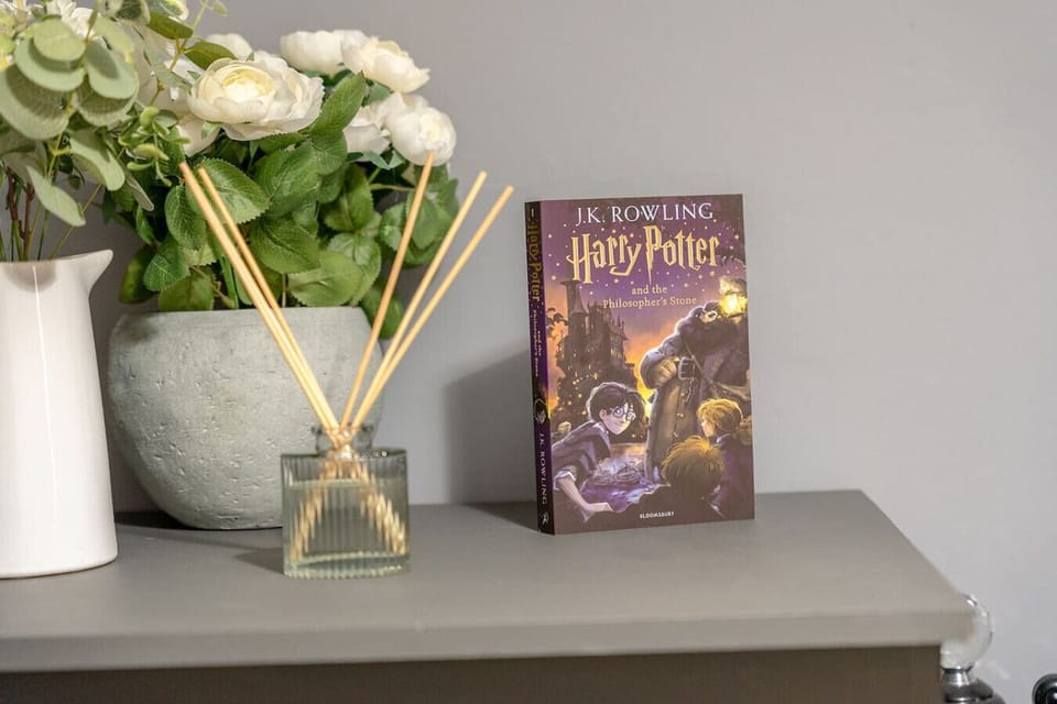 Shelf styling with flowers, a diffuser, and a book as a finishing touch.