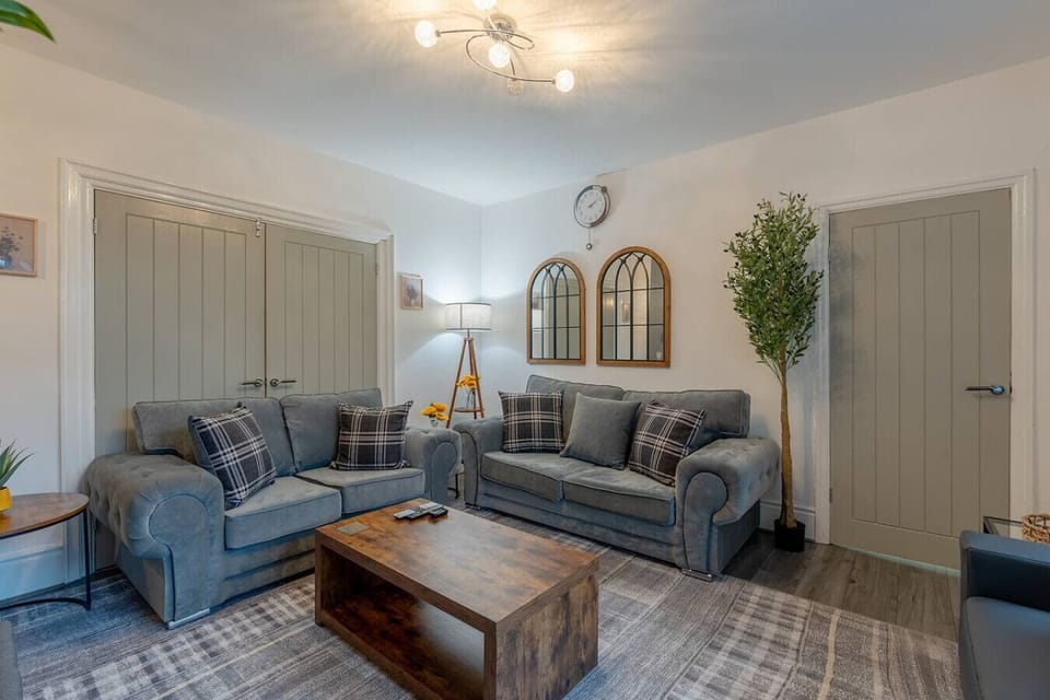 Wide living room view showing multiple sofas and the central coffee table