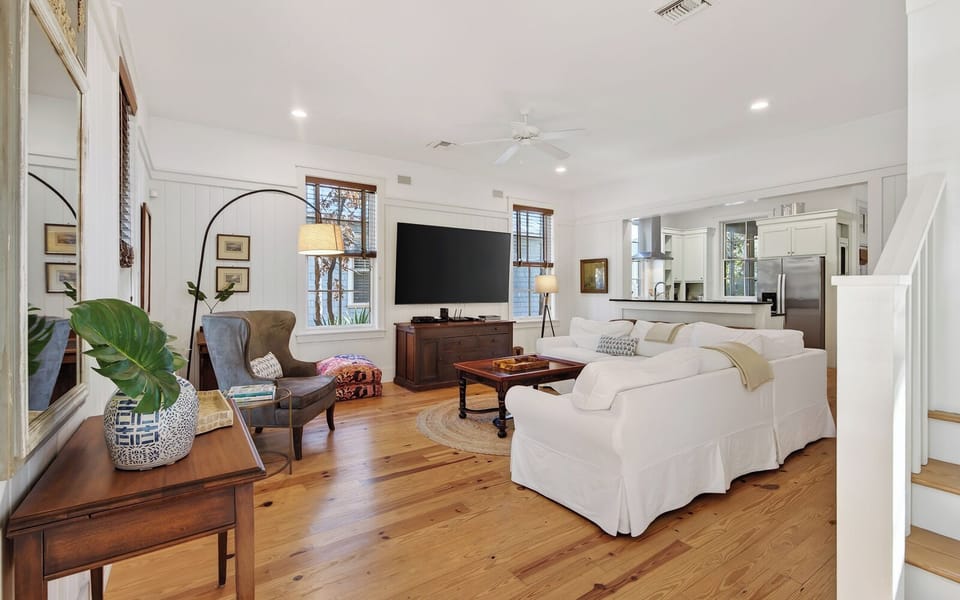 Sink into plush white sofas surrounded by warm wood floors and thoughtful coastal touches that create your perfect relaxation retreat.