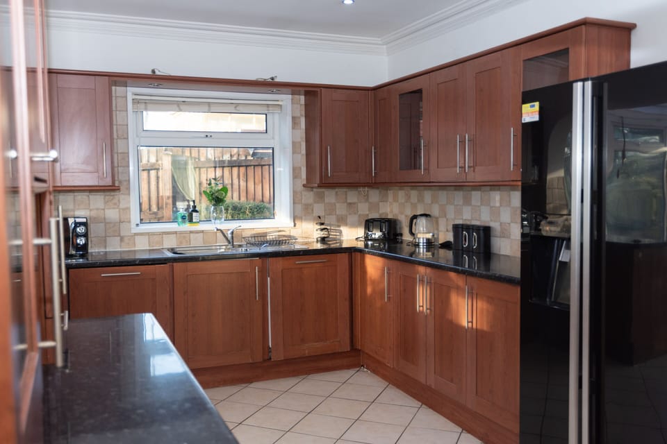 Generous, well-equipped kitchen with an American-style double fridge freezer, integrated appliances, and all the cookware, crockery, and cutlery needed for up to 16+ guests, making group meals and family gatherings effortless