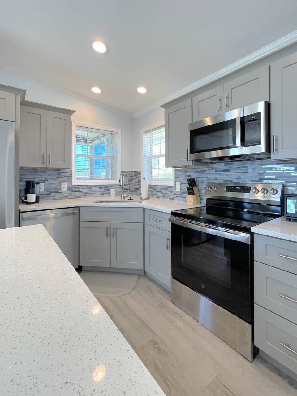 Fully equipped kitchen features modern appliances, granite counters, and stylish backsplash.