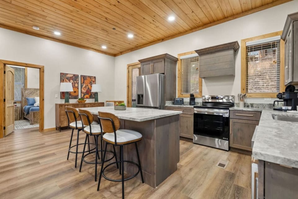 Whip up a pancake breakfast or a full family dinner in this stylish, fully stocked kitchen. Stainless appliances, warm wood cabinetry, and a central island bar make it a space everyone will want to gather in.