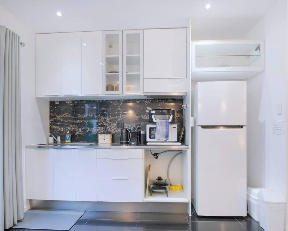 The compact kitchenette makes light meals and easy mornings simple, equipped with a fridge, microwave, oven, toaster, kettle, and espresso machine.
