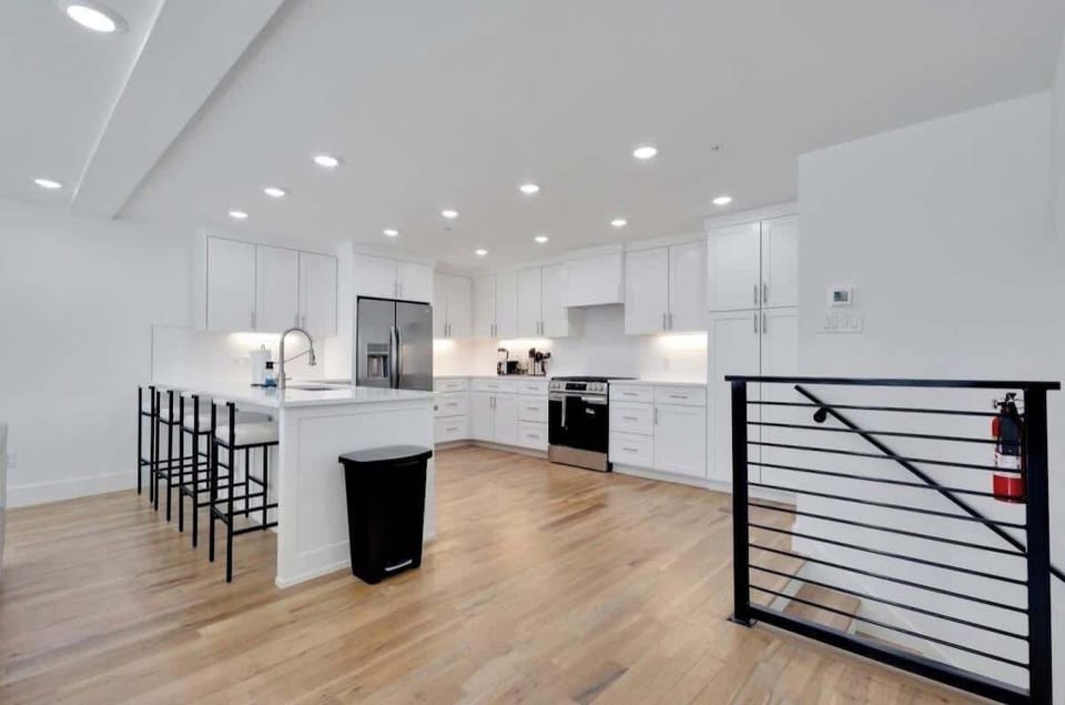 Spacious, modern kitchen with white cabinetry, stainless-steel appliances, and a large island with seating—bright, open, and perfect for entertaining.