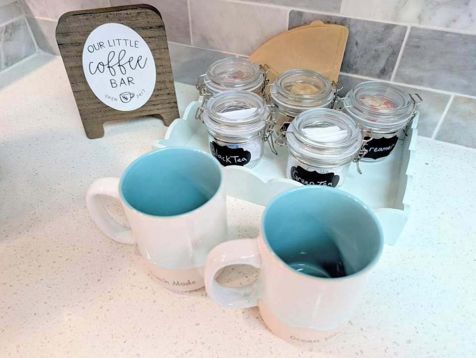Charming coffee & tea bar - labeled jars, mugs, filters, and all the fixings.