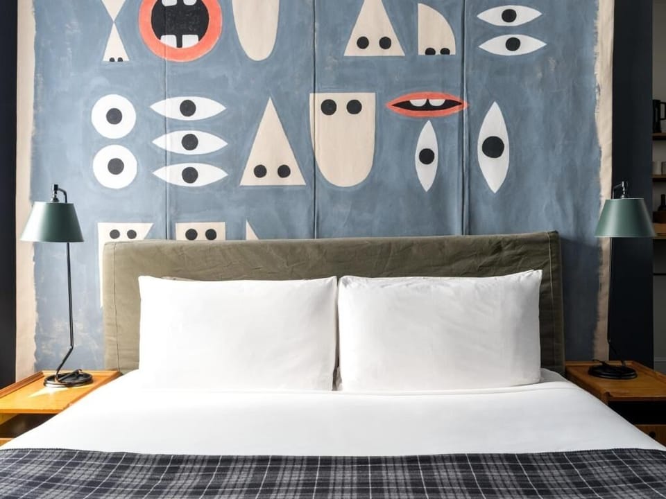 Sink into cloud-soft pillows beneath bold, artistic wall design.