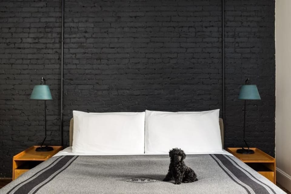 Sink into crisp linens against a dramatic, moody brick backdrop.