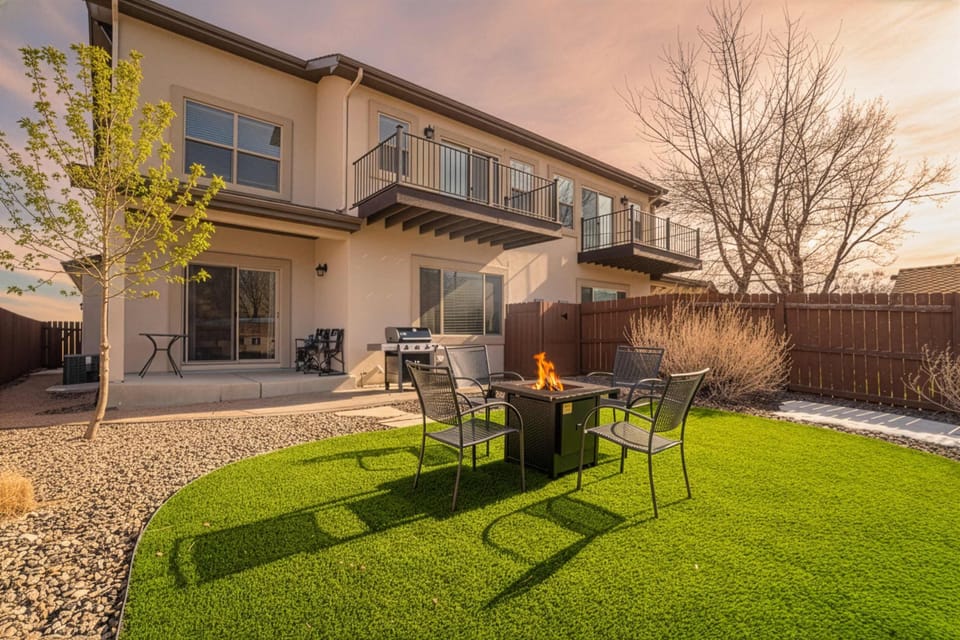 Welcome to Westland Base! This modern mountain retreat features a private, fully fenced backyard with a manicured turf lawn and a cozy fire pit area for evening relaxation.