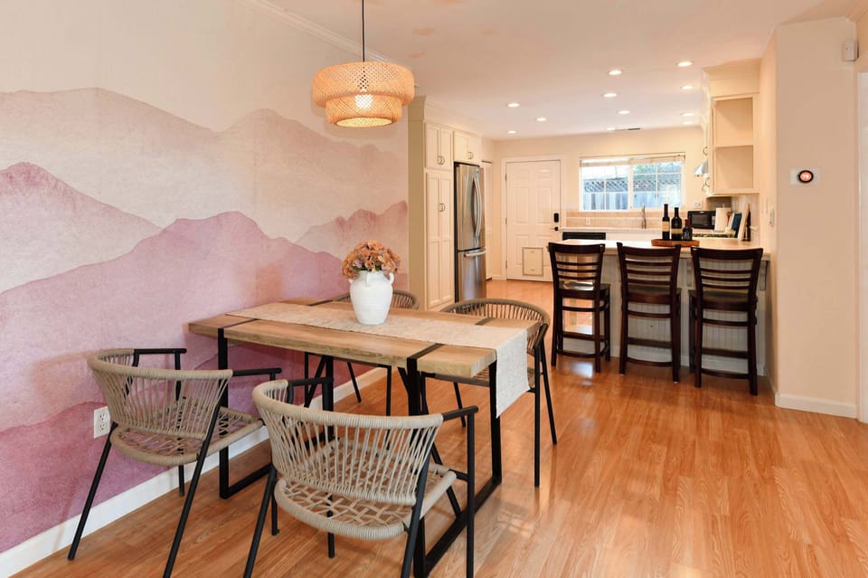 Inviting dining nook with modern decor and a unique accent wall, flowing seamlessly into the comfortable living area.