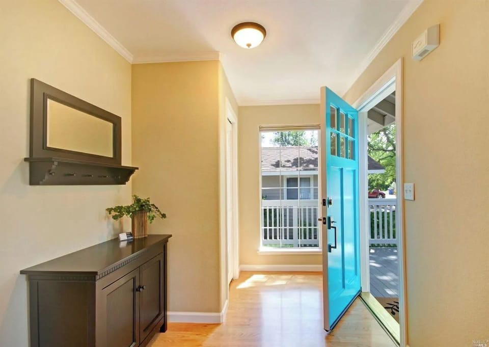 Inviting foyer filled with natural light, featuring a stylish console table and easy access to the charming front porch.