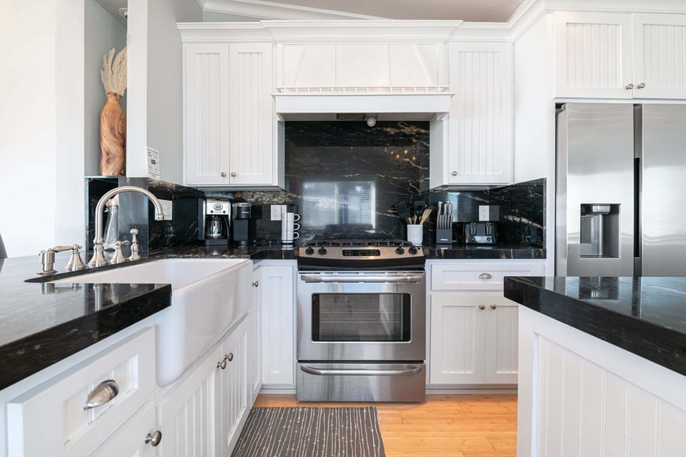Cook with ease in the sleek modern kitchen, featuring updated cabinetry, polished countertops, and stainless steel appliances
                
