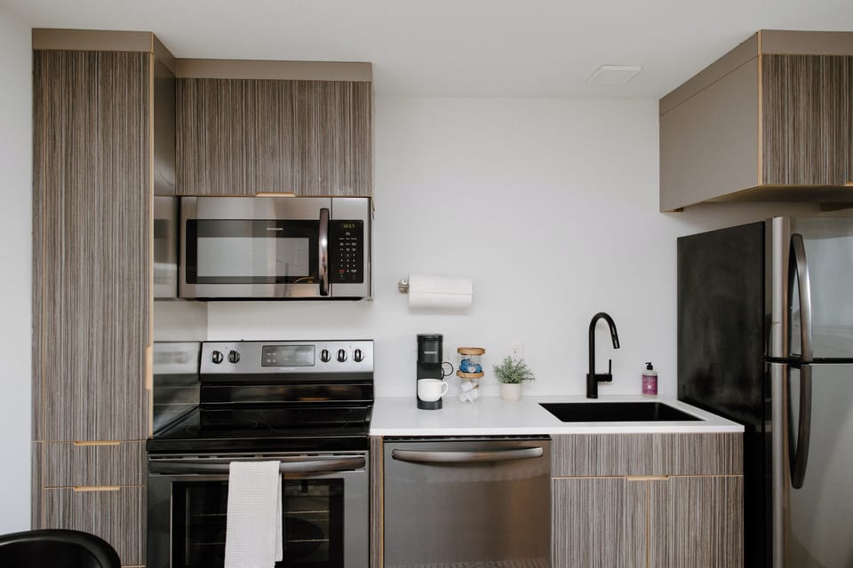 Cook with ease in a fully equipped kitchen featuring a dishwasher, full‑size appliances, cookware, and all essential kitchen tools for extended stays