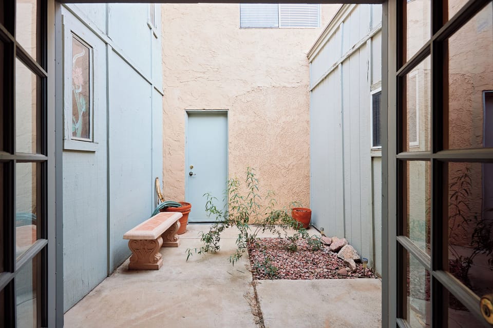 Primary Bedroom featuring a King bed, smart TV, cozy furnishings, walk-in closet, access to a private patio and an en-suite bathroom.