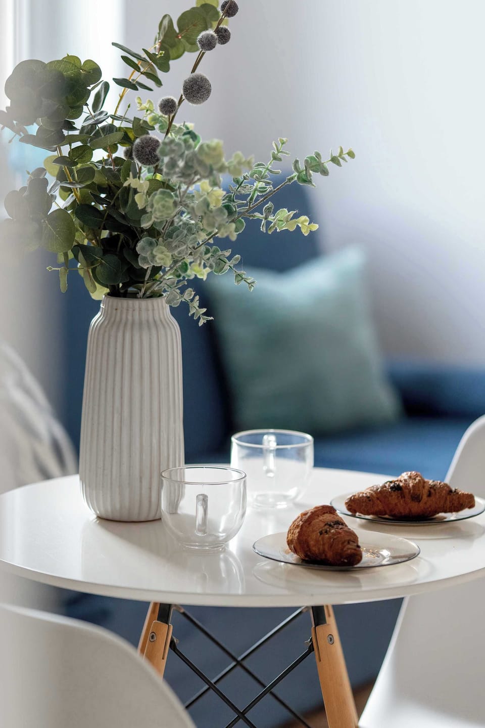 A close-up of a small table with a vase and decorative items. Soft colors and natural materials create a cozy detail. The styling feels minimal and elegant.