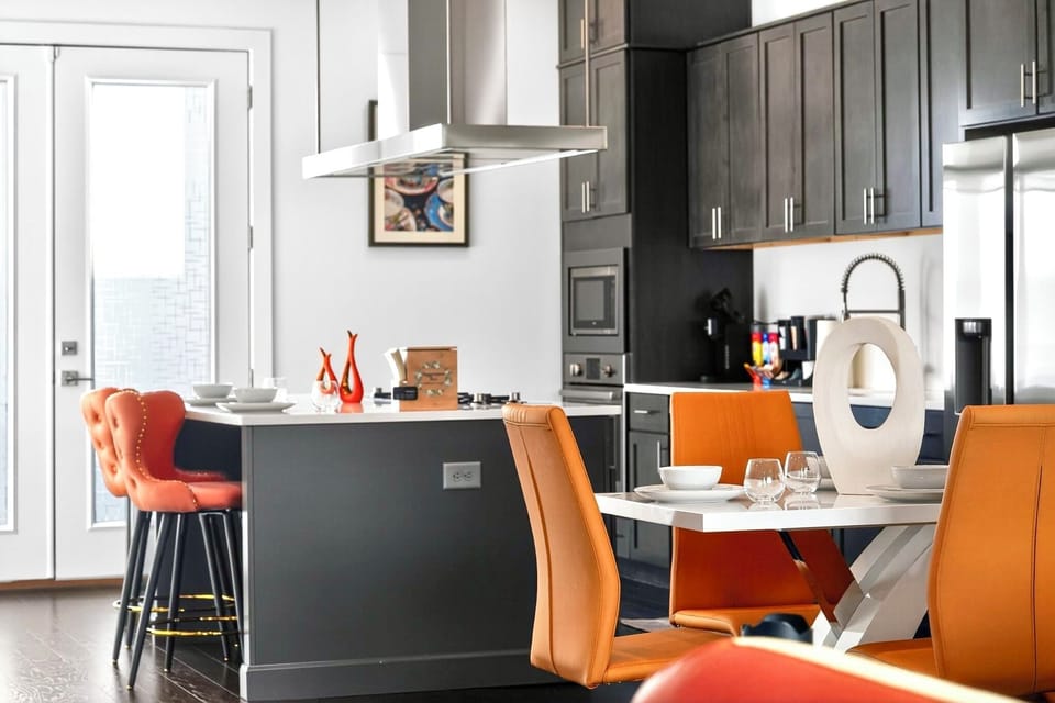 Modern chef’s kitchen with island seating and bold designer dining accents