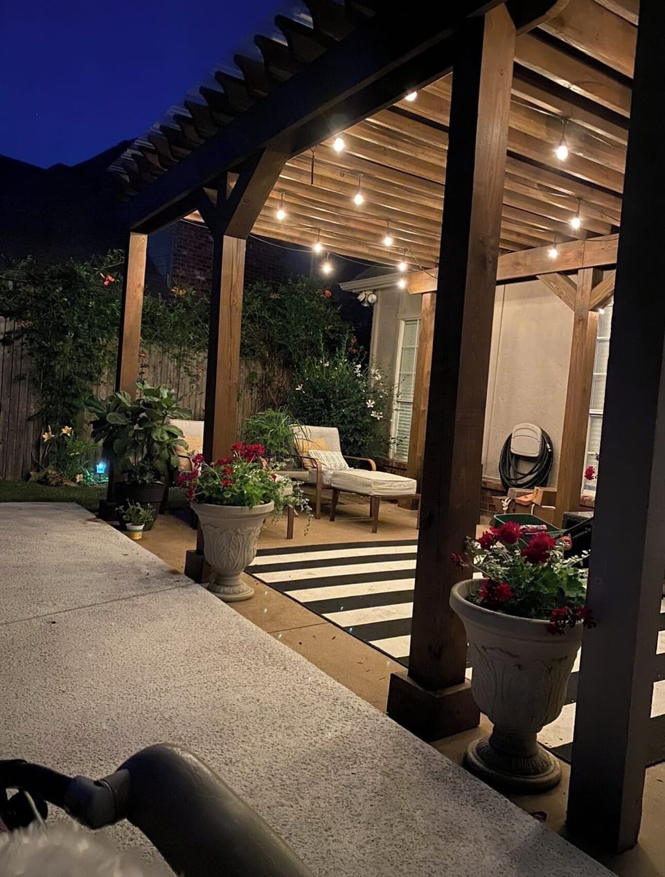Back patio with covered pergola, string lights and outdoor TV