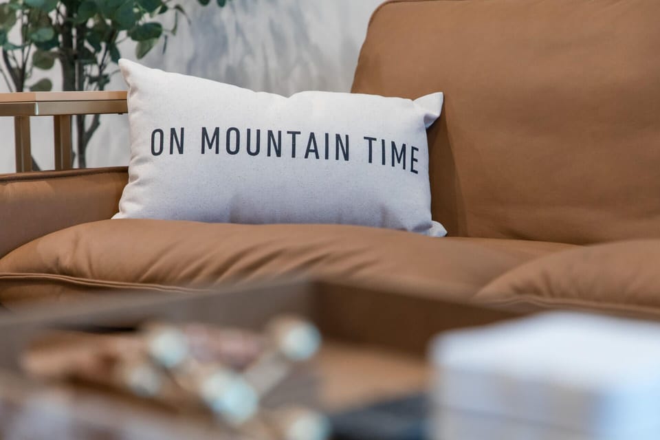 Sink into this cozy leather sofa with the perfect accent pillow that captures your mountain getaway mood perfectly.