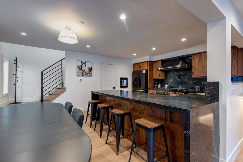Your sleek kitchen features rich walnut cabinets and dramatic dark countertops, perfect for morning coffee or evening gatherings.