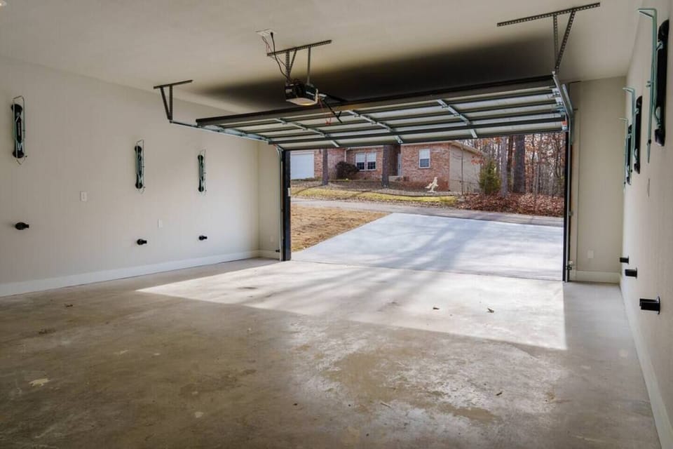 Spacious garage with a wide-open door, clean concrete flooring, and plenty of natural light—ready for parking or storage