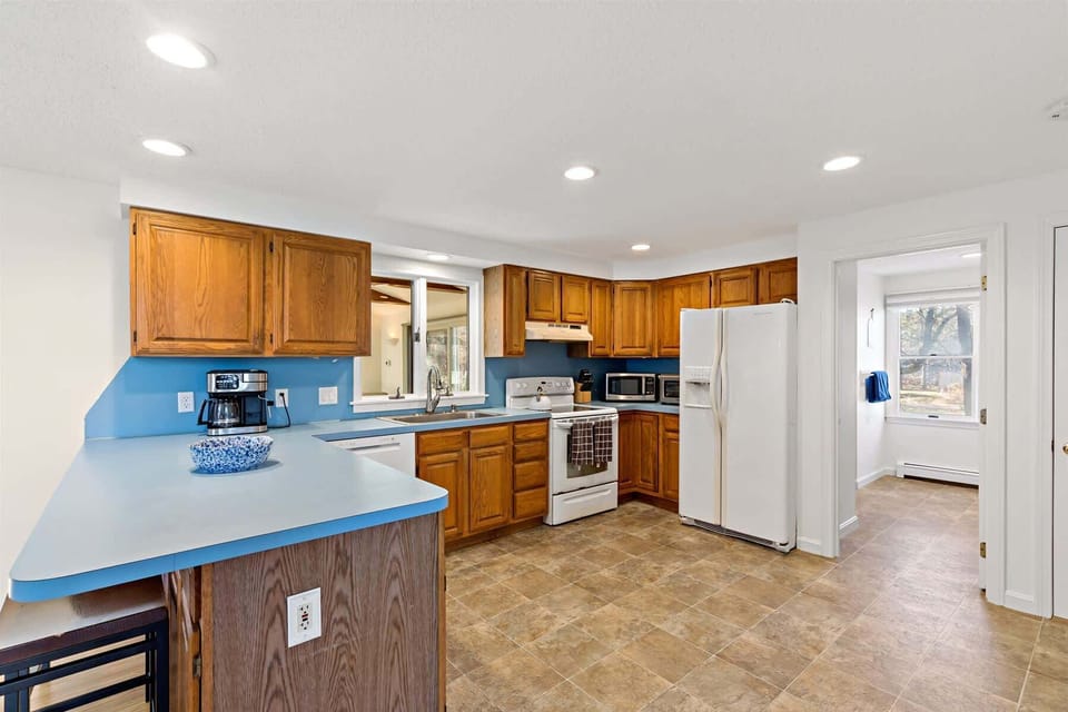 Bright kitchen with breakfast bar and full appliance setup, ready for practical Cape Cod vacation cooking.