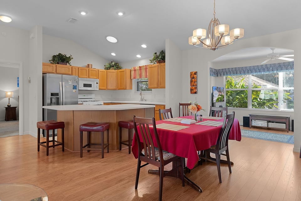 Your spacious kitchen and dining area flows seamlessly with modern appliances, elegant chandelier, and breakfast bar for memorable meals together.
