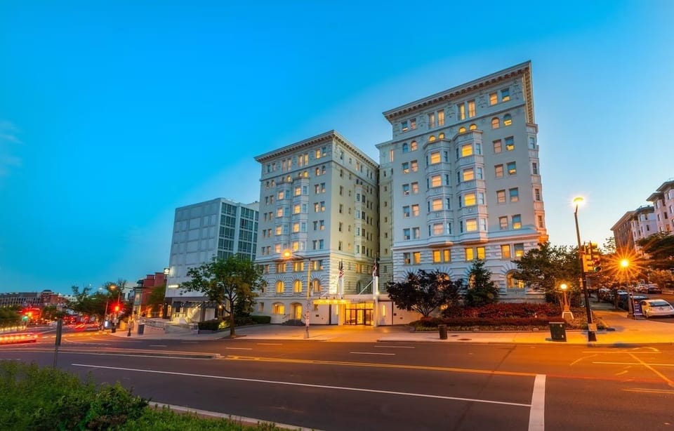 Arrive to a grand, glowing facade in the evening.