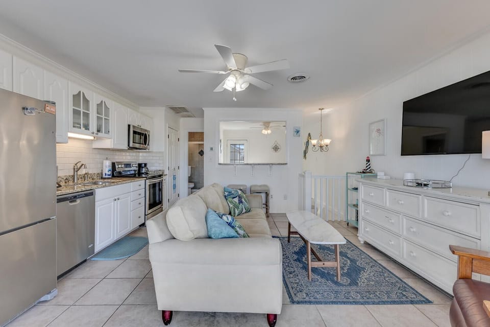 Relax in your bright, coastal-themed living space with modern kitchen, comfy seating, and beachy touches throughout.