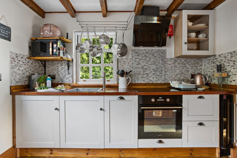 Kitchen area with hob and oven, microwave and slim dishwasher - Beryas Cottage