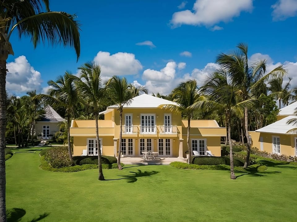 Arrive to a sunlit villa framed by swaying palms.